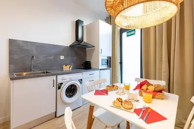 a kitchen with a table and a sink and a washing machine at Travel Habitat Ruzafa Lofts in Valencia