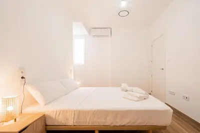 a bedroom with a bed with white walls at VisitVal Flats 1 in Valencia