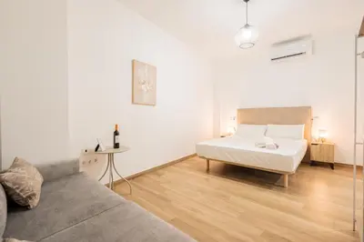 a white bedroom with a bed and a couch at VisitVal Flats 2 in Valencia