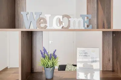 a shelf with a welcome sign and a potted plant at VisitVal Flats 3 in Valencia