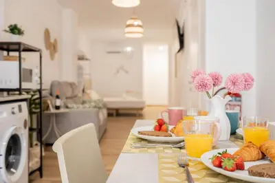 a table with plates of food and drinks in a living room at VisitVal Flats 3 in Valencia