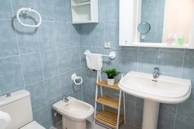 a bathroom with a white sink and a toilet at Espacio2,1a línea,jacuzzi,piscina in Cullera