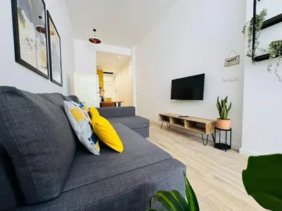 a living room with a gray couch with yellow pillows at New Industrial Design Flat in Russafa SOHO in Valencia