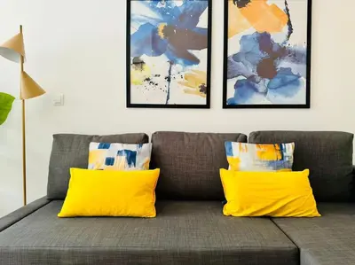 a couch with two yellow pillows in a living room at New Industrial Design Flat in Russafa SOHO in Valencia