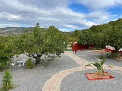 a garden with a table and chairs and trees at Finca El Escondite in Olocau