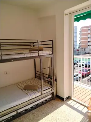 a red couch in a living room with two pictures at Apartamento con parking frente a la playa in Faro de Cullera