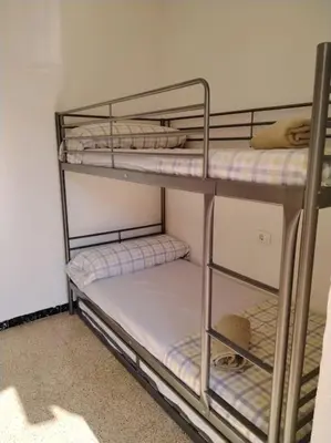 a room with three bunk beds in a room at Apartamento con parking frente a la playa in Faro de Cullera