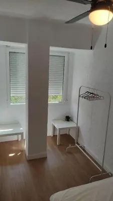 a white room with a bed and two windows at Alojamiento junto Aeropuerto Valencia A in Manises