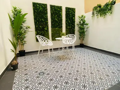 two chairs and a table on a tiled floor with plants at Apartamento Ciencias & Maritim in Valencia