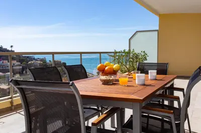 a wooden table with a bowl of fruit on a balcony at Sea View Terrace Apartment Cullera in Cullera