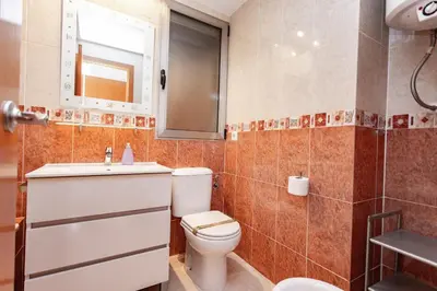 a bathroom with a toilet and a sink and a mirror at Sea View Terrace Apartment Cullera in Cullera