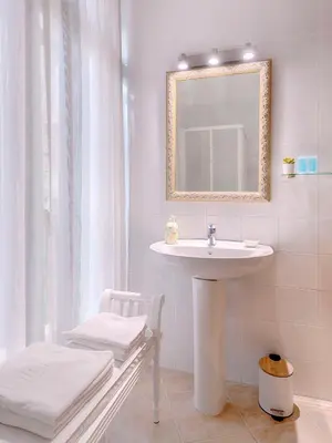 a white bathroom with a sink and a mirror at Hostal Antigua Morellana in Valencia