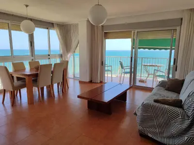 a living room with a couch and a table and chairs at Aloha frente al Mar in Cullera