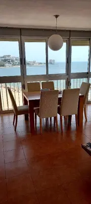 a dining room with a table and chairs and the ocean at Aloha frente al Mar in Cullera