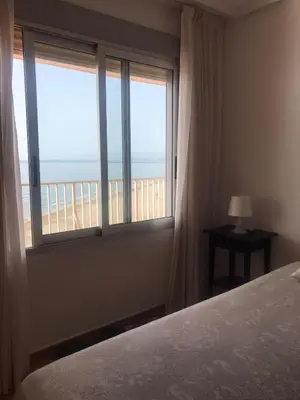 a bedroom with a bed and a view of the ocean at Aloha frente al Mar in Cullera