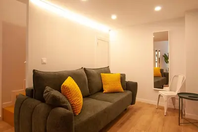 a living room with a gray couch with yellow pillows at Quiet Loft in Valencia