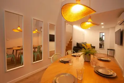 a dining room with a large wooden table and yellow lights at Quiet Loft in Valencia