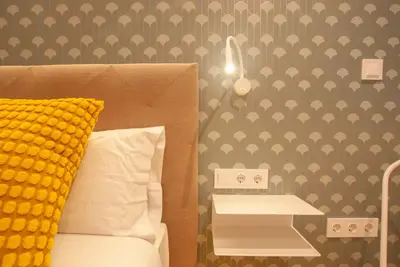 a bedroom with a bed with a yellow pillow and a table at Quiet Loft in Valencia