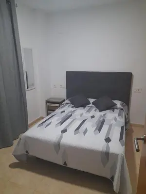 a bedroom with a bed with a black and white comforter at SERRATELLA Puerto in El Puerto