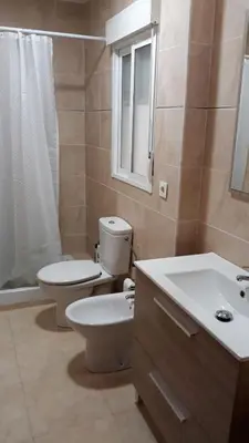 a bathroom with a toilet and a sink and a mirror at SERRATELLA Puerto in El Puerto
