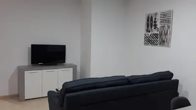 a living room with a couch and a flat screen tv at SERRATELLA Puerto in El Puerto