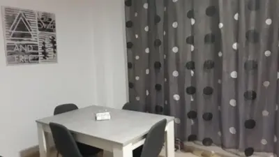 a table and chairs in a room with a curtain at SERRATELLA Puerto in El Puerto