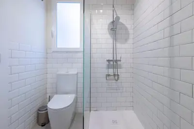 a white bathroom with a toilet and a window at Your home at Valencia Cabañal 2 in Valencia