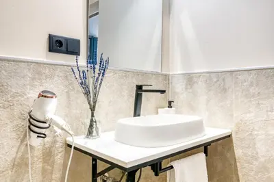 a bathroom with a white sink and a mirror at City Scape Suites in Valencia