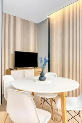 a white dining room with a white table and chairs at City Scape Suites in Valencia