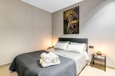 a bedroom with a bed with towels on it at City Scape Suites in Valencia