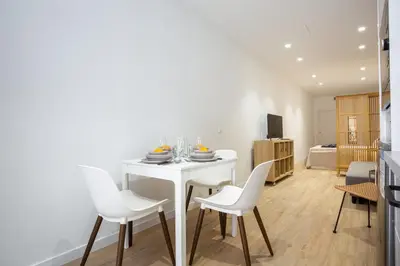 a dining room with a white table and white chairs at Nuevo piso cerca de universidad y playa in Valencia