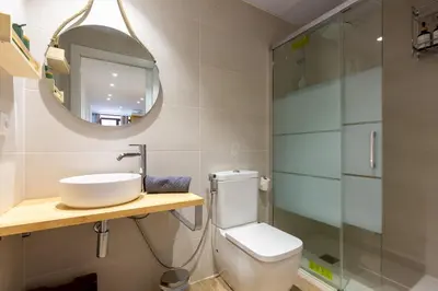 a bathroom with a sink and a toilet and a mirror at Nuevo piso cerca de universidad y playa in Valencia