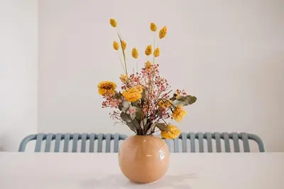 a vase with flowers in it sitting on a table at Lofts plaza Orense A New and close to the beach in Valencia