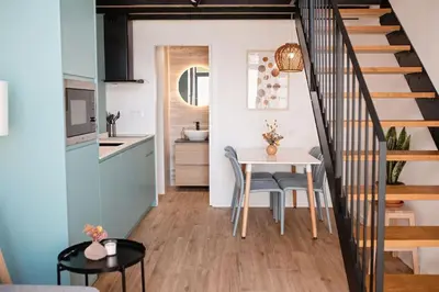 a kitchen and dining room with a table and a staircase at Lofts plaza Orense A New and close to the beach in Valencia