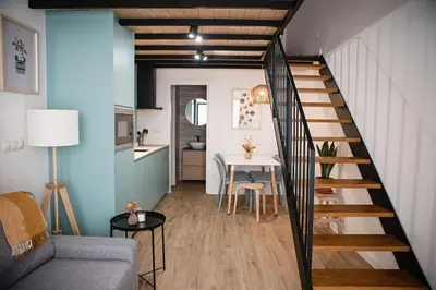 a living room with a staircase leading to a kitchen at Lofts plaza Orense A New and close to the beach in Valencia