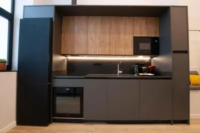 a black kitchen with a sink and a refrigerator at LOFT Accommodative B in Valencia