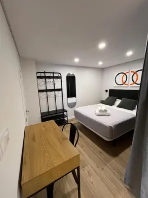 a bedroom with a bed and a wooden table at LOFT Accommodative A in Valencia