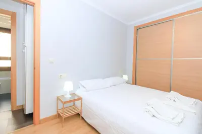 a bedroom with a large white bed with a wooden headboard at BET Apartments - Tramontana Apartments in Valencia