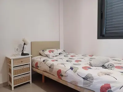 a bedroom with a bed and a night stand at Amplio duplex en la playa con piscina in Almarda