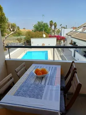a bowl of oranges on a table on a balcony at Amplio duplex en la playa con piscina in Almarda