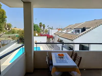 a balcony with a table with a bowl of fruit on it at Amplio duplex en la playa con piscina in Almarda