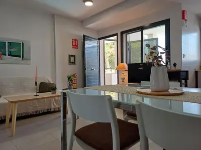 a living room with a glass table and chairs at Amplio duplex en la playa con piscina in Almarda