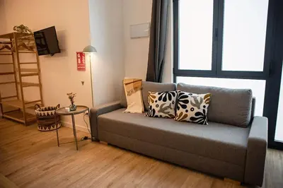 a living room with a couch with pillows on it at Lofts Orense E Moderno y cercano a la playa in Valencia