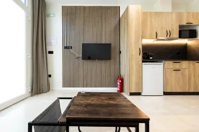 a living room with a table and a kitchen at Vera Suites by Concept Flats in Valencia