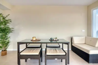 a dining room with a table and chairs and a couch at Luxury Penthouse with Panoramic Sea Views in Canet de Berenguer