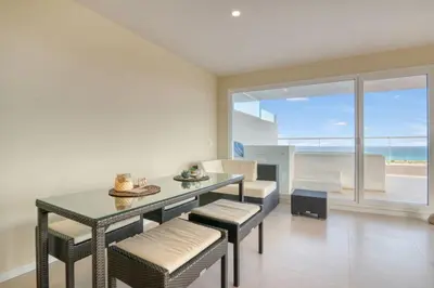 a dining room with a table and chairs and the ocean at Luxury Penthouse with Panoramic Sea Views in Canet de Berenguer