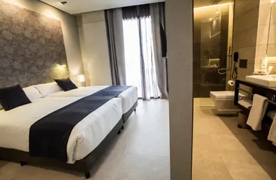 a bedroom with a large bed and a bathroom at Vincci Mercat in Valencia