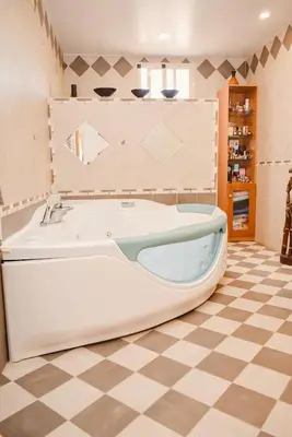 a bath tub in a bathroom with a checkered floor at Sunny House La Eliana in La Eliana
