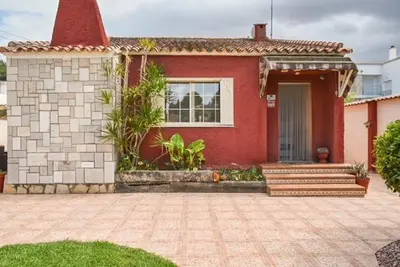 a red house with a porch and stairs in front of it at Sunny House La Eliana in La Eliana