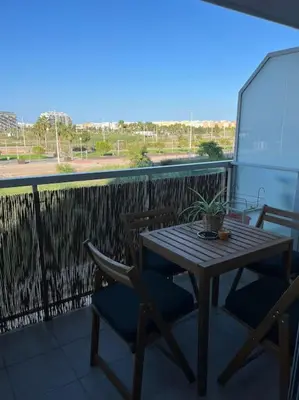 a wooden table and chairs on a balcony at Apartamento en Moncofa in Moncófar